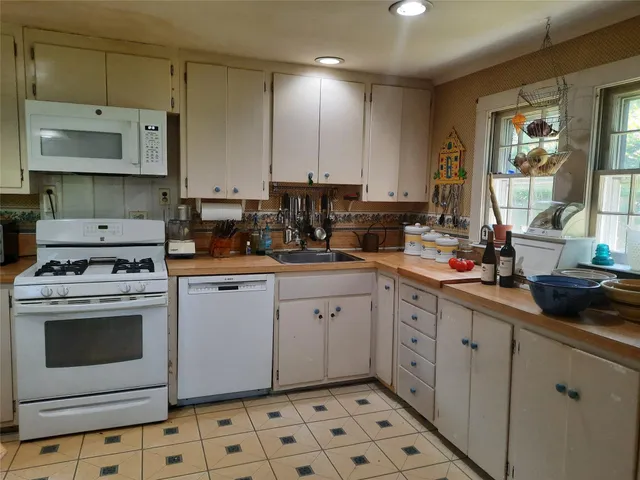 a view of a backyard with potted plants and wooden fence