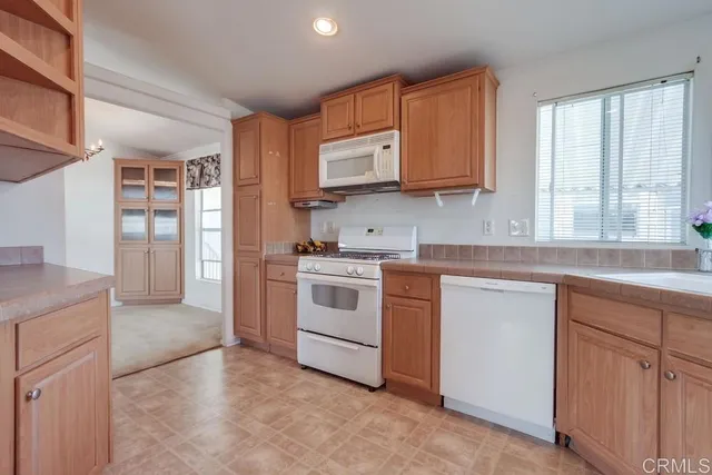 a kitchen with white cabinets and white appliances