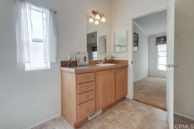 a bedroom with bed mirror and window