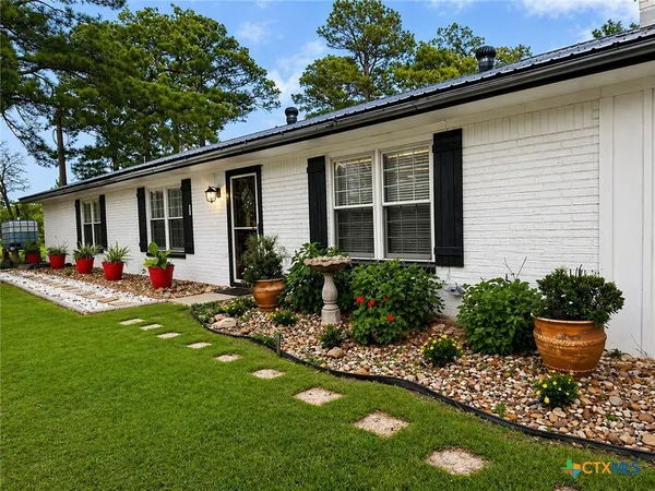 a view of a house with backyard and sitting area