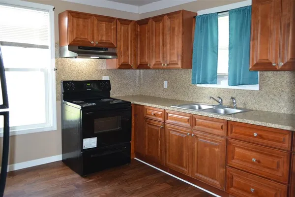 a kitchen with stainless steel appliances granite countertop a stove a sink and a microwave