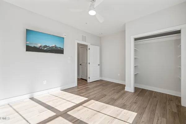a view of a room with wooden floor and white walls