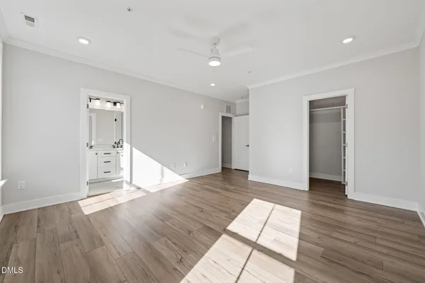 an empty room with wooden floor and mirror