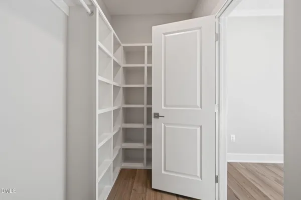 a view of walk in closet with empty racks