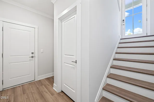 a view of a hallway with wooden floor and entryway