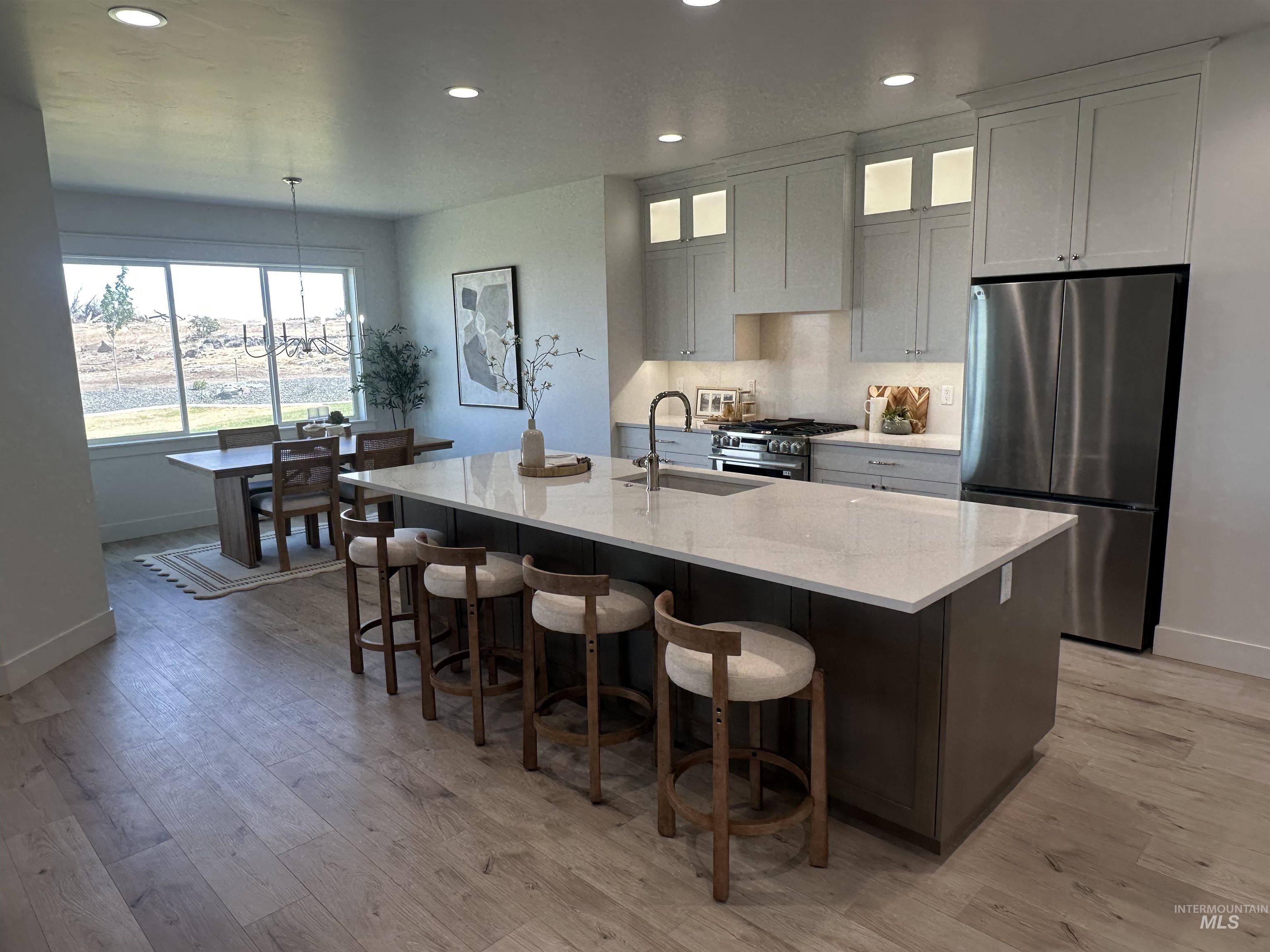 3035 Lake View Twin Falls, ID 83301 - Photo 4 of 41 Open concept kitchen and dining area featuring a large center island with seating, stainless steel appliances, light wood-finish flooring, and ample cabinetry