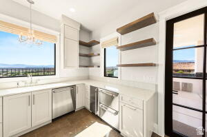 1141 East Lost Ridge Drive Washington, UT 84780 - Photo 41 of 108 Bright kitchen area featuring white cabinetry, light countertops, wood-finish flooring, stainless steel appliances, and large windows with mountain scenery