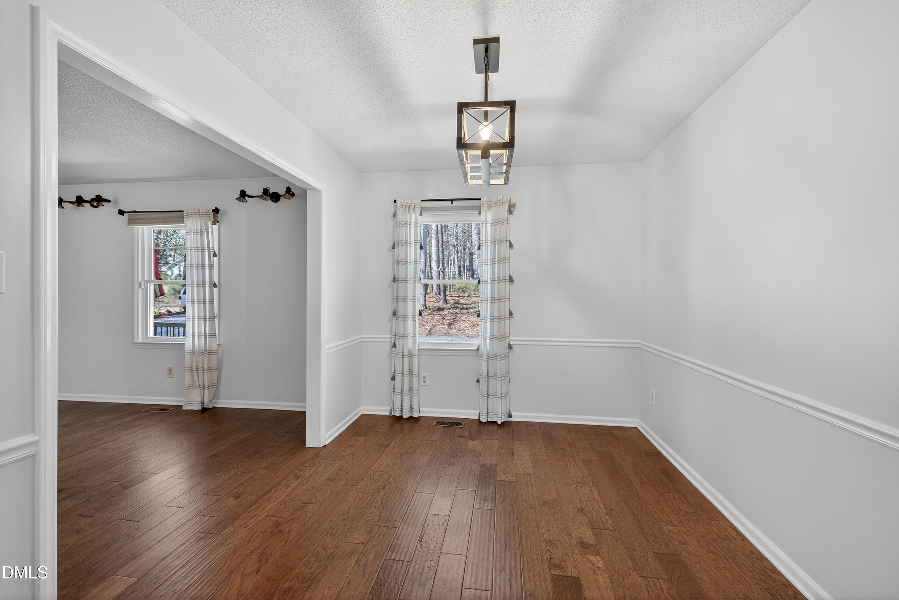 810 Woodland Road Creedmoor, NC 27522 - Photo 13 of 77 an empty room with wooden floor and windows