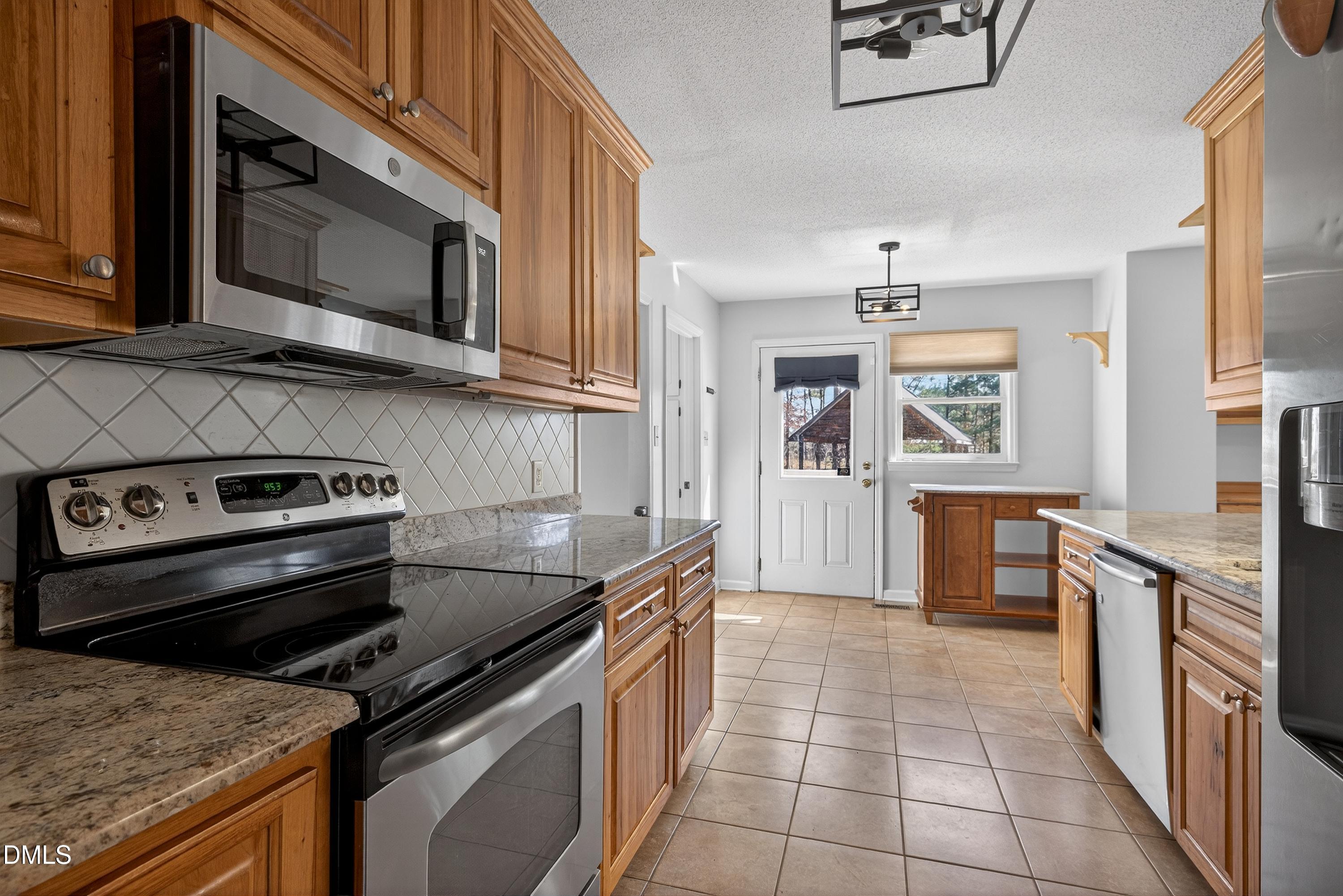 810 Woodland Road Creedmoor, NC 27522 - Photo 14 of 77 a kitchen with a stove microwave and cabinets