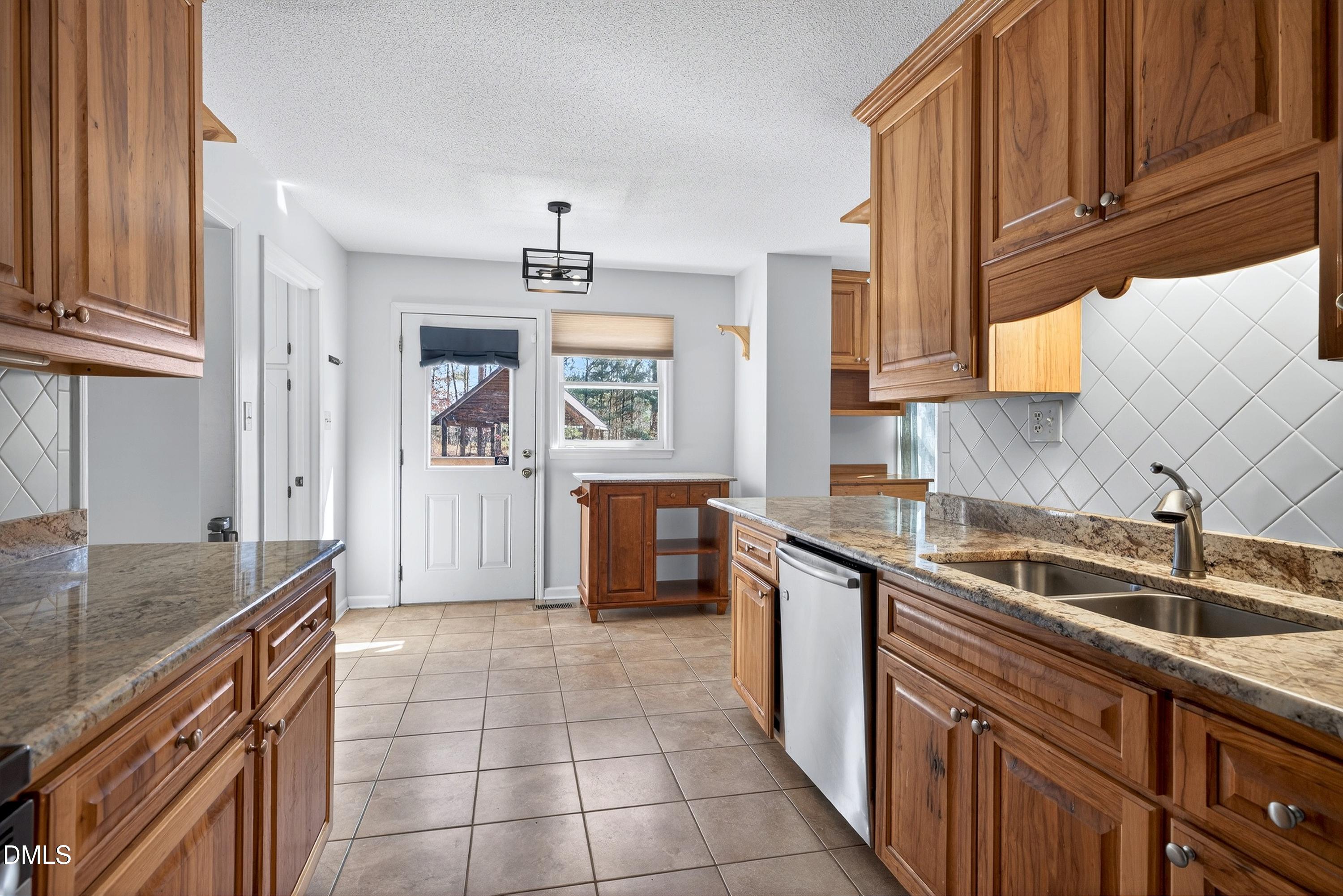 810 Woodland Road Creedmoor, NC 27522 - Photo 15 of 77 a kitchen with stainless steel appliances granite countertop a sink stove and cabinets