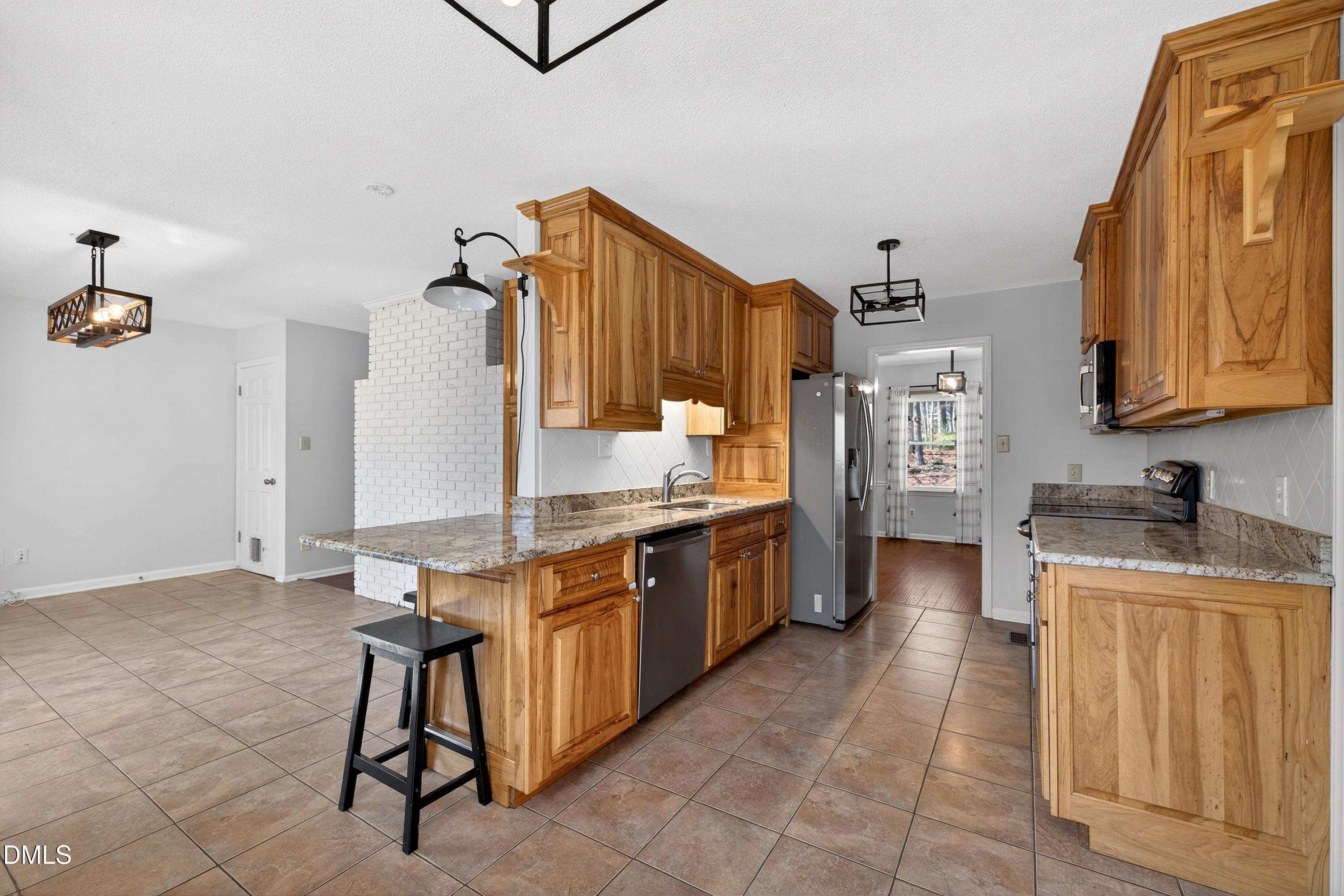 810 Woodland Road Creedmoor, NC 27522 - Photo 17 of 77 a kitchen with stainless steel appliances granite countertop a sink and cabinets