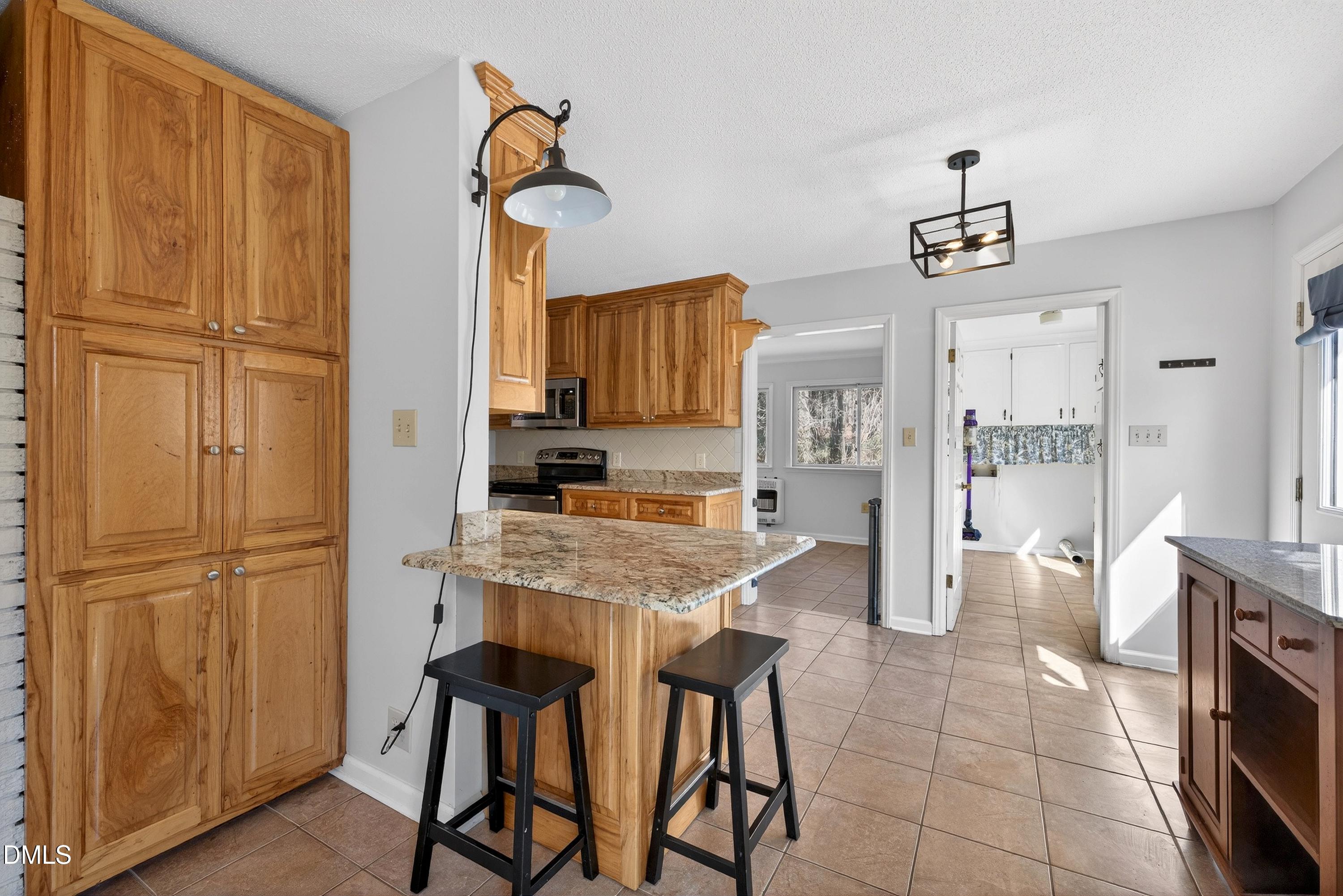 810 Woodland Road Creedmoor, NC 27522 - Photo 19 of 77 a kitchen with stainless steel appliances granite countertop a refrigerator and a stove top oven