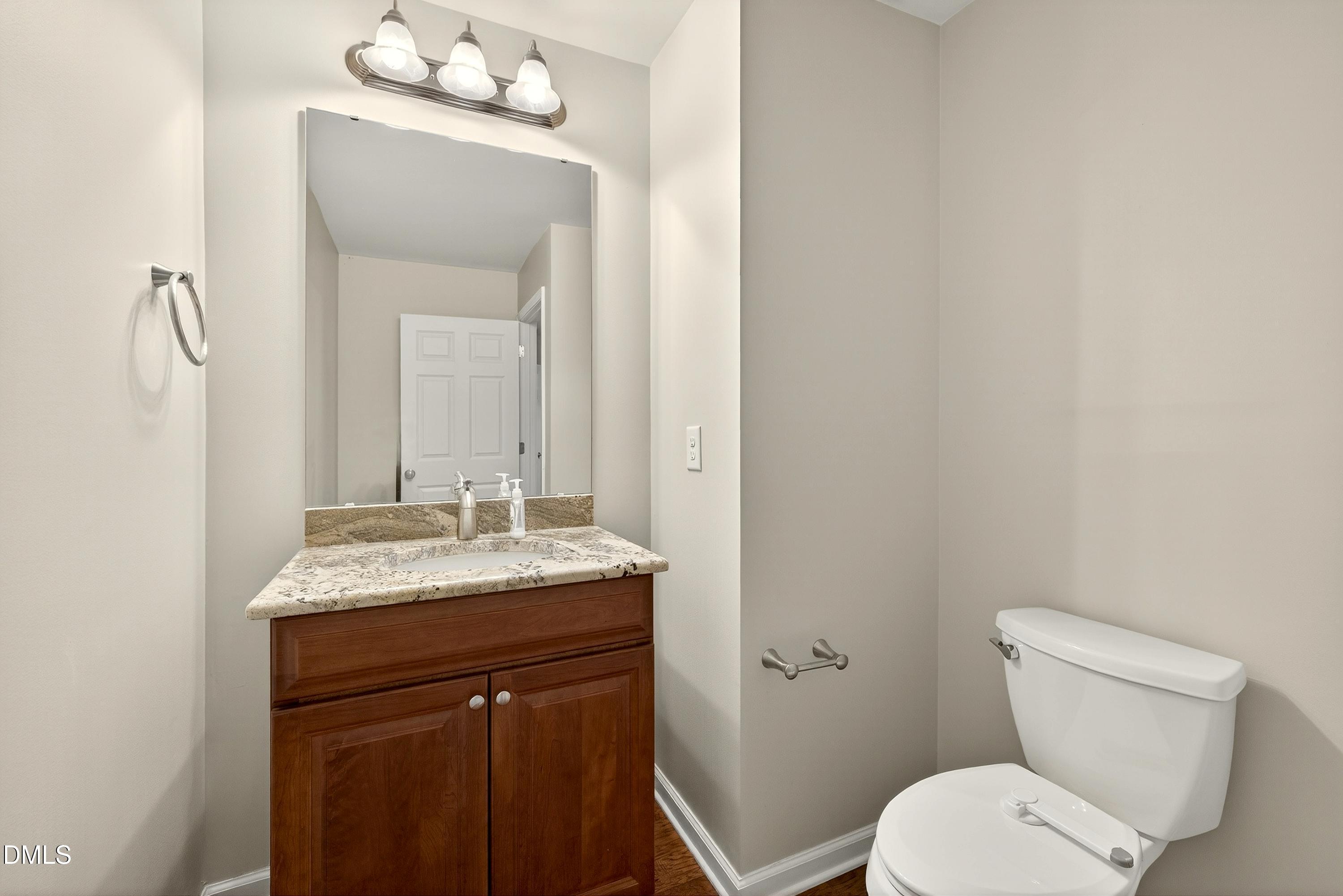 810 Woodland Road Creedmoor, NC 27522 - Photo 30 of 77 a bathroom with a granite countertop toilet sink and mirror