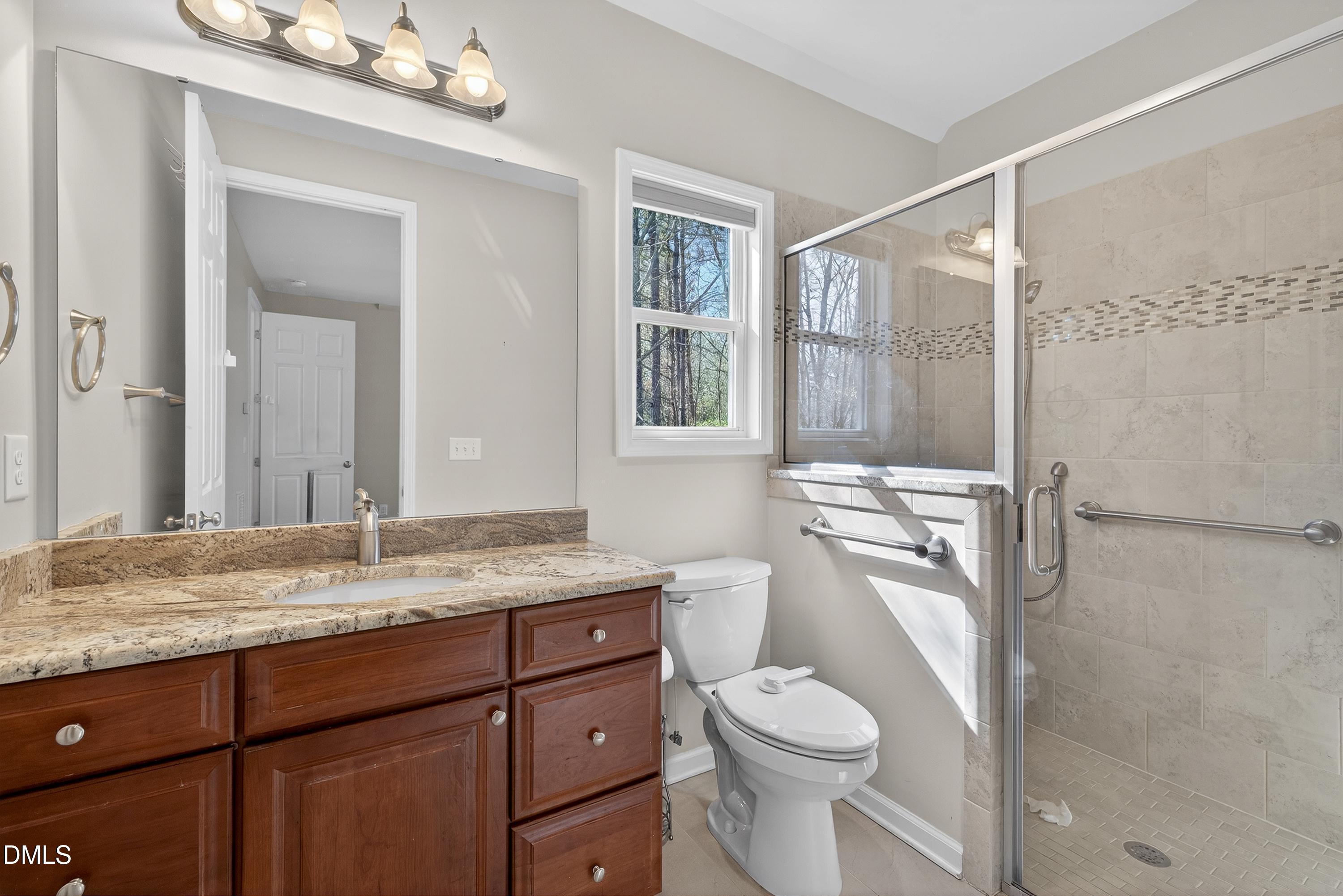 810 Woodland Road Creedmoor, NC 27522 - Photo 41 of 77 a bathroom with a granite countertop sink toilet and shower