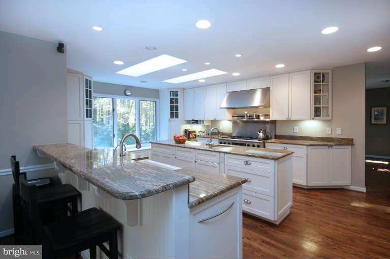 525 Clear Spring Road Great Falls, VA 22066 - Photo 9 of 30 a kitchen with granite countertop kitchen island sink stove and white cabinets