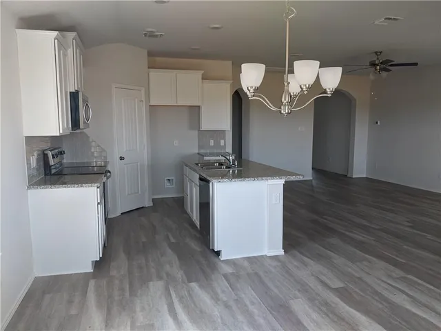 a kitchen with a sink dishwasher a refrigerator and wooden floor