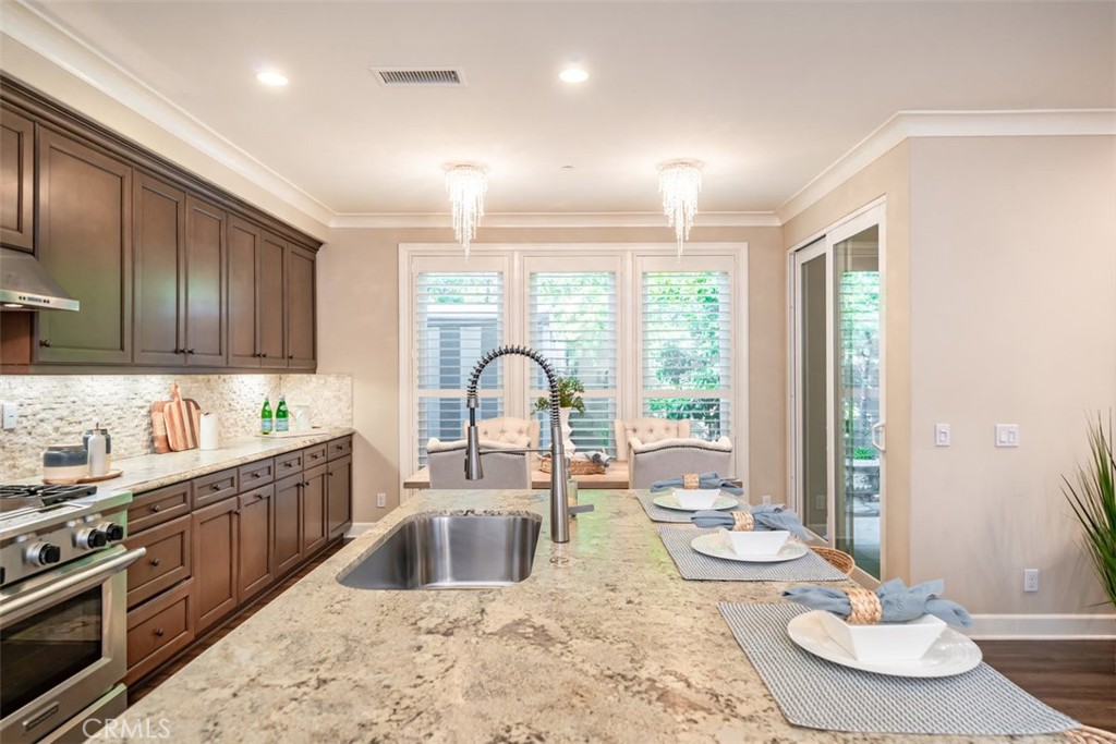 43 Lupari Irvine, CA 92618 - Photo 13 of 68 a kitchen with stainless steel appliances kitchen island granite countertop a sink and large windows