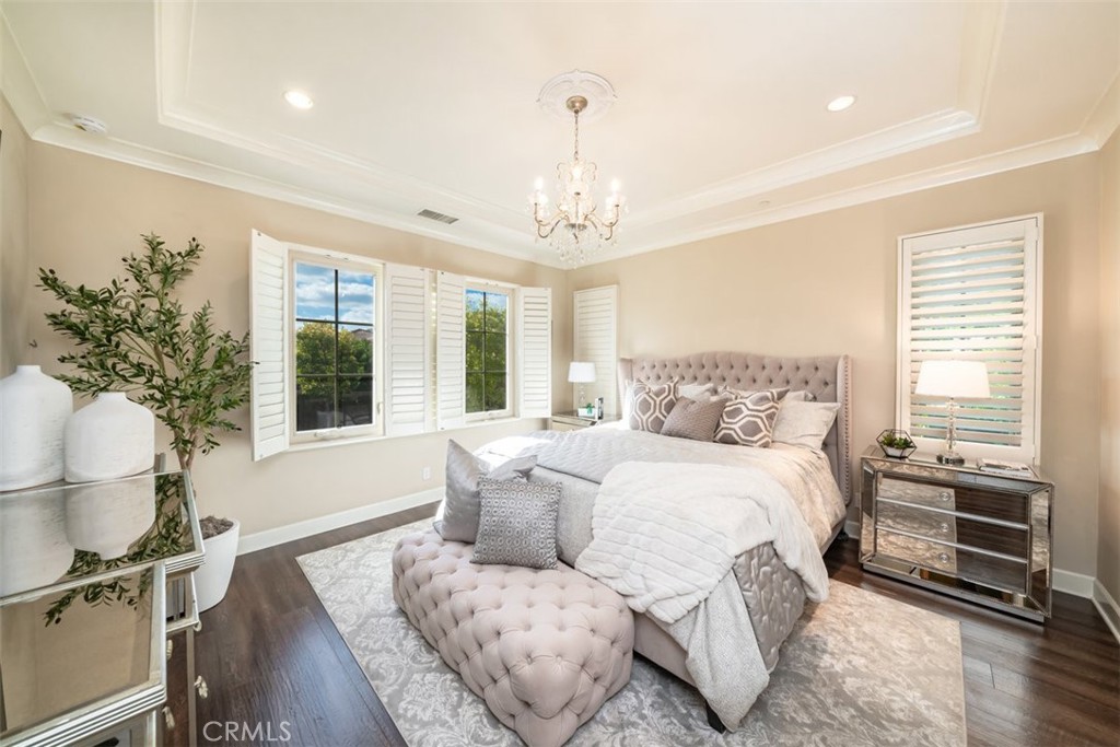 43 Lupari Irvine, CA 92618 - Photo 38 of 68 a spacious bedroom with a bed and a chandelier