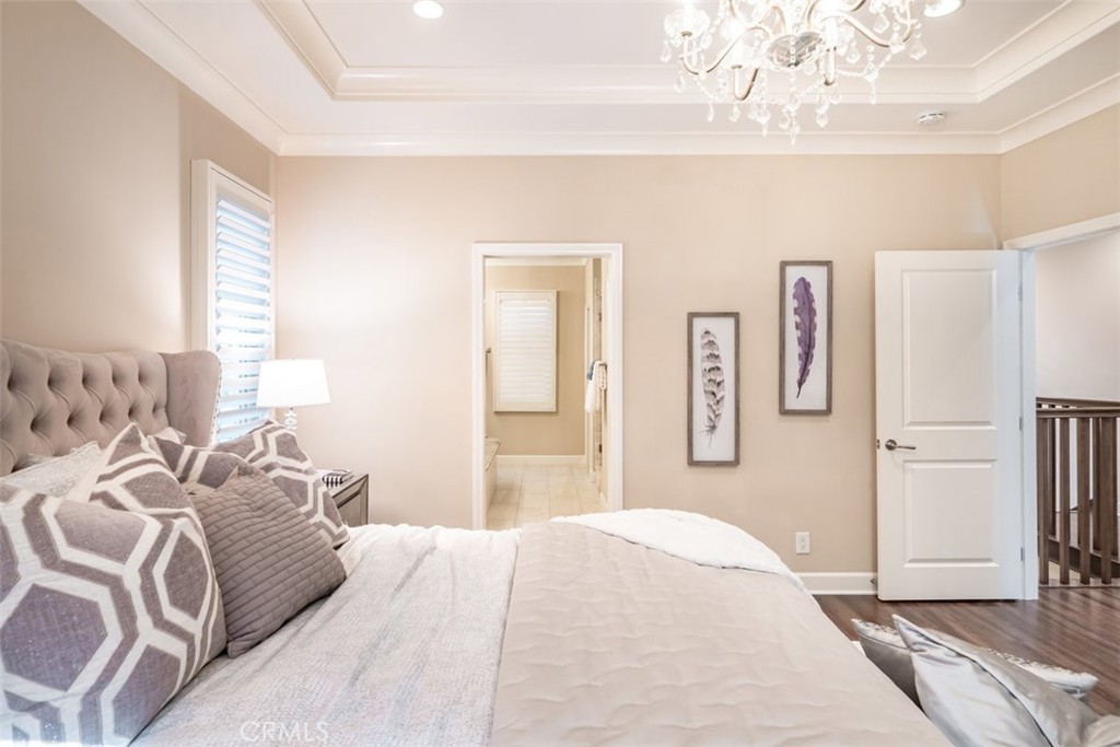 43 Lupari Irvine, CA 92618 - Photo 42 of 68 a bedroom with a large bed and a chandelier