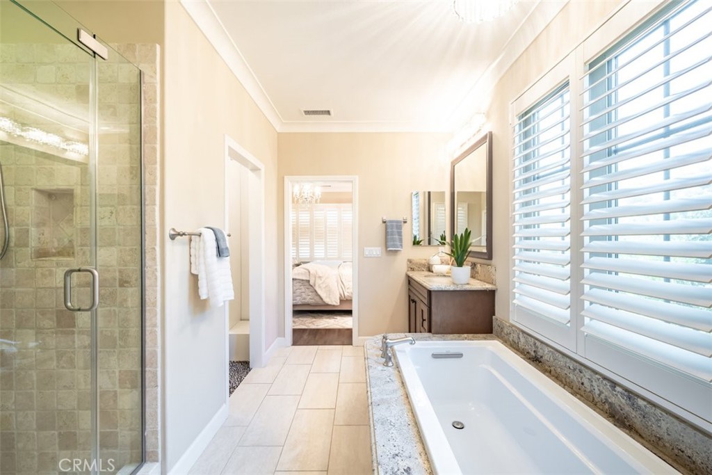 43 Lupari Irvine, CA 92618 - Photo 48 of 68 a bathroom with a tub a sink and a large mirror next to a window