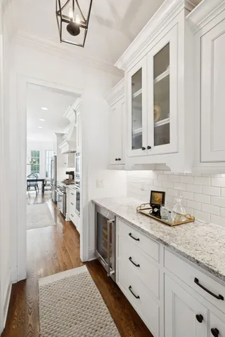 a living room with furniture kitchen view and a chandelier