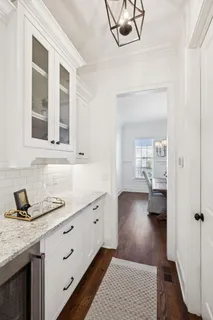 a kitchen with stainless steel appliances granite countertop a stove a refrigerator a kitchen island a dining table and chairs with wooden floor