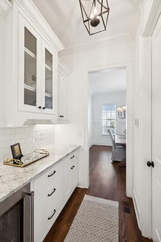 a kitchen with stainless steel appliances granite countertop a stove a refrigerator a kitchen island a dining table and chairs with wooden floor