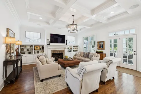 a large living room with fireplace furniture and a chandelier