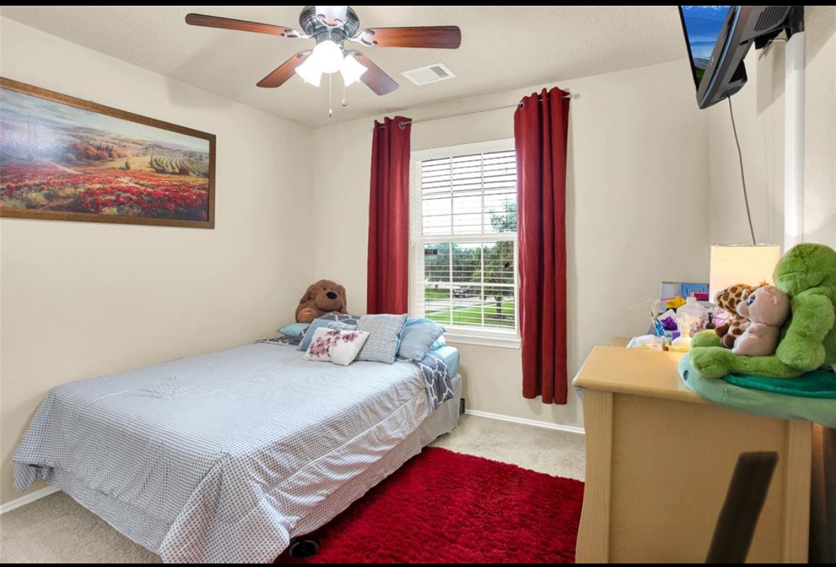 7035 Primrose Road Baytown, TX 77521 - Photo 13 of 18 a bedroom with a bed and a chandelier