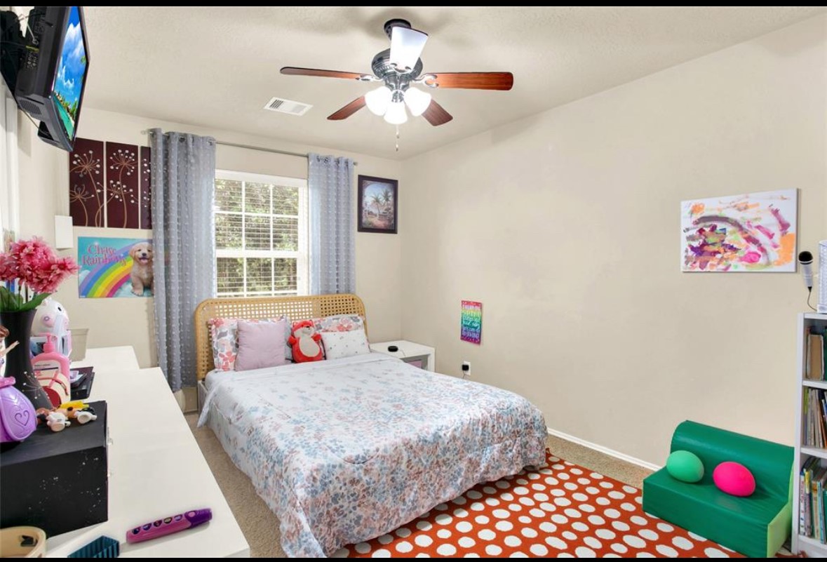 7035 Primrose Road Baytown, TX 77521 - Photo 14 of 18 a bedroom with a bed and a chandelier