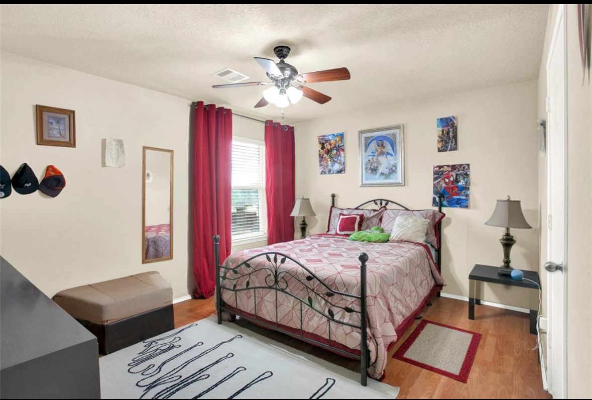 7035 Primrose Road Baytown, TX 77521 - Photo 15 of 18 a bedroom with a bed and a chandelier