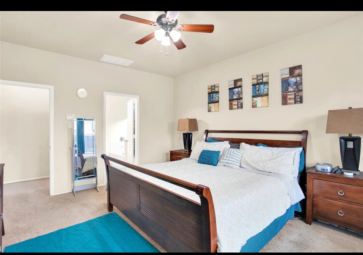 7035 Primrose Road Baytown, TX 77521 - Photo 9 of 18 a bed room with a bed and a chandelier