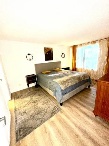 a bedroom with a bed and wooden floor