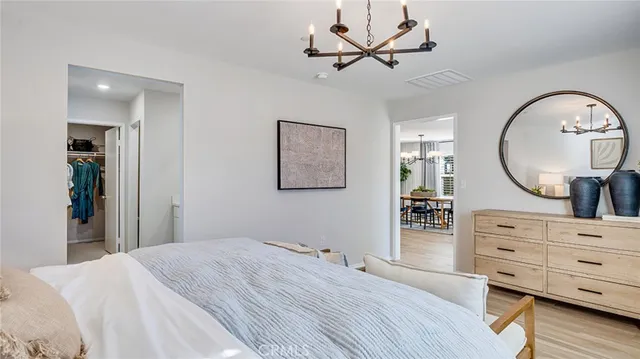 a bedroom with a bed a dresser and mirror