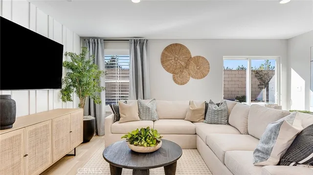 a living room with furniture a flat screen tv and a large window