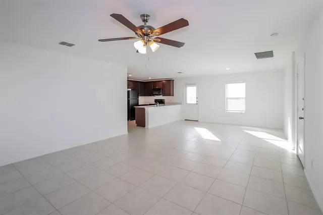 an empty room with windows and fan
