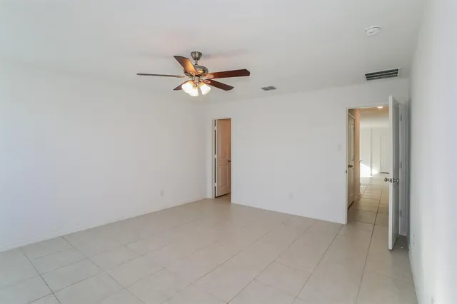 an empty room with closet and a chandelier fan