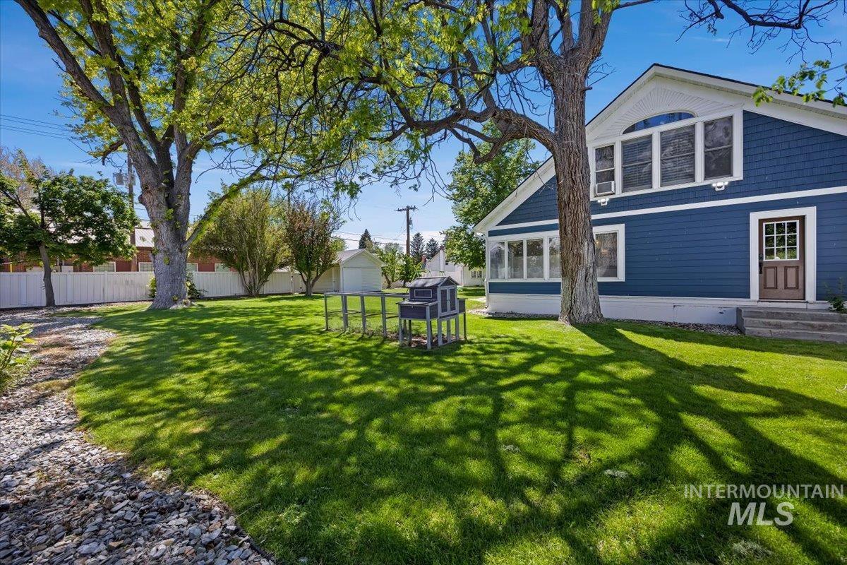 813 7th Street Rupert, ID 83350 - Photo 38 of 48 Expansive yard featuring mature trees, a manicured lawn, and a white privacy fence