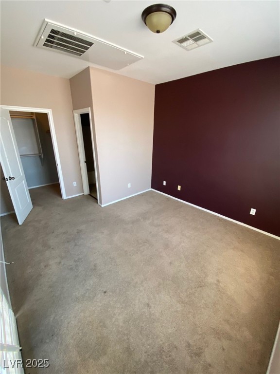 5817 Addy Lane, Unit N North Las Vegas, NV 89081 - Photo 8 of 32 Unfurnished bedroom featuring a walk in closet, carpet, and attic access