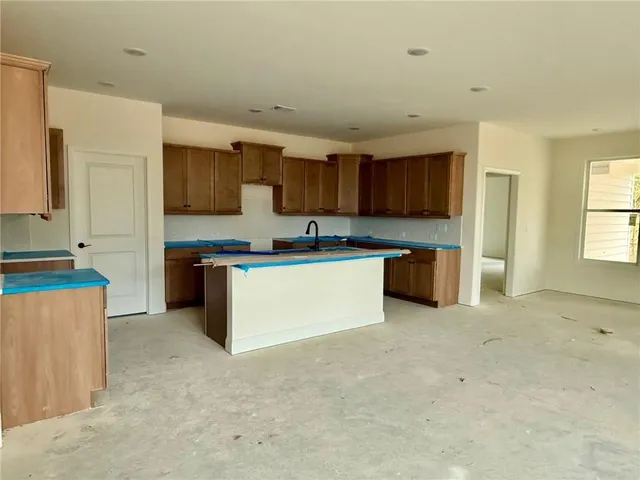 a kitchen with stainless steel appliances a sink a stove top oven a counter space and cabinets