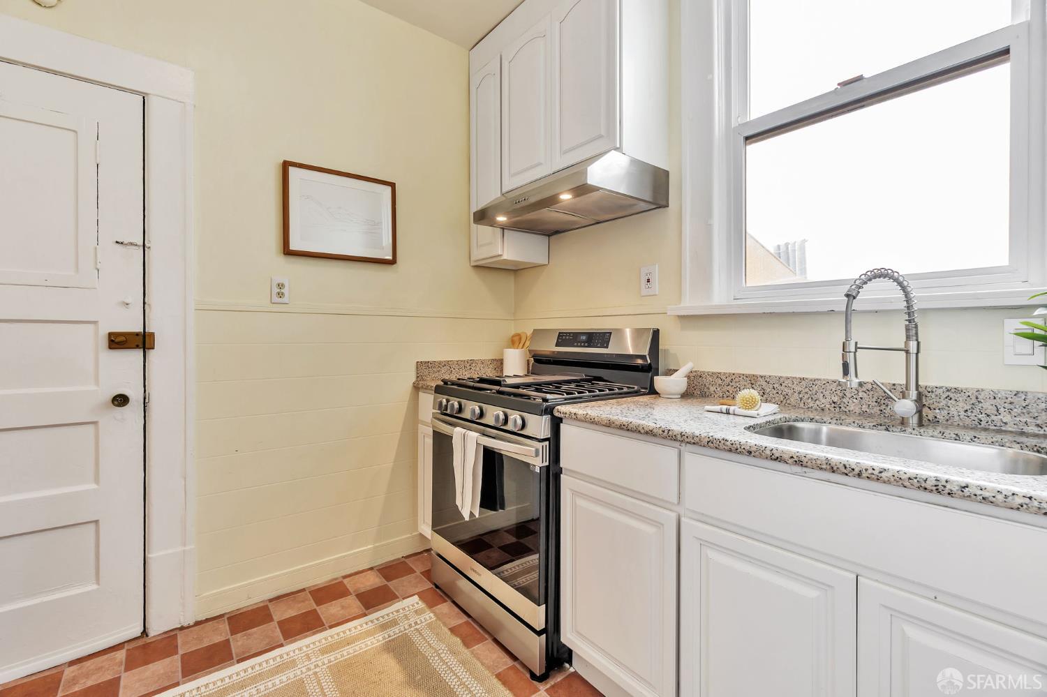 1180 Jackson Street, Unit 6 San Francisco, CA 94109 - Photo 11 of 48 a kitchen with stainless steel appliances granite countertop a sink a stove and a refrigerator