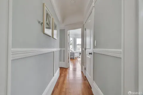 a view of a hallway with wooden floor and staircase