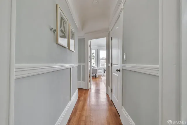 a view of a hallway with wooden floor and staircase