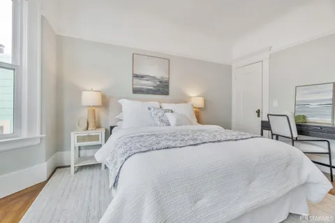 a bedroom with a bed and a painting on the wall