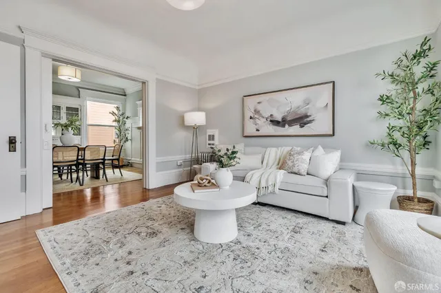 a living room with furniture a dining table and a potted plant