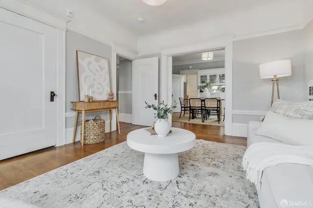 a living room with furniture a mirror and a lamp