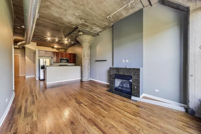 a view of a livingroom with wooden floor and a fireplace