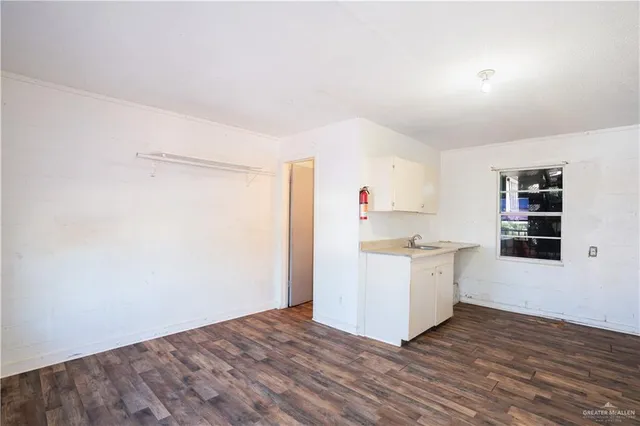 a kitchen with a sink cabinets and wooden floor