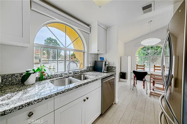 a kitchen with white cabinets and appliances