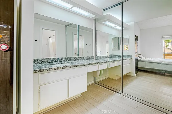 a bathroom with a granite countertop sink and a mirror